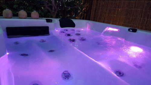 a white bath tub with pink lights in it at Charming House in Maspalomas