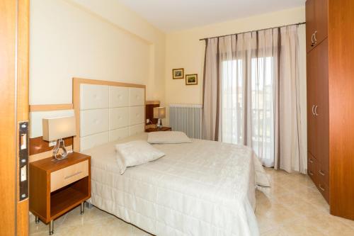 Un dormitorio con una cama blanca y una ventana. en House Maria, en Agios Nikolaos