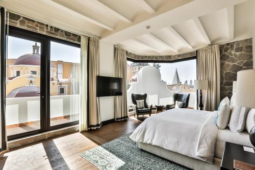 a bedroom with a bed and a large window at Banyan Tree Puebla in Puebla