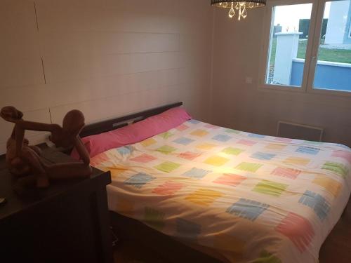 een slaapkamer met een bed met een kleurrijk dekbed bij le Tic Tac in Vergongheon