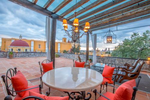 a patio with a table and chairs on a balcony at Banyan Tree Puebla in Puebla