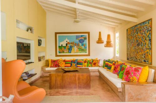 a living room with a couch with colorful pillows at Jardim de Trancoso Pousada in Trancoso