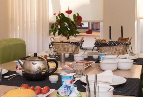einen Tisch mit einem Wasserkocher und Geschirr darauf in der Unterkunft Bed & Breakfast Onder de Dekens in Harderwijk