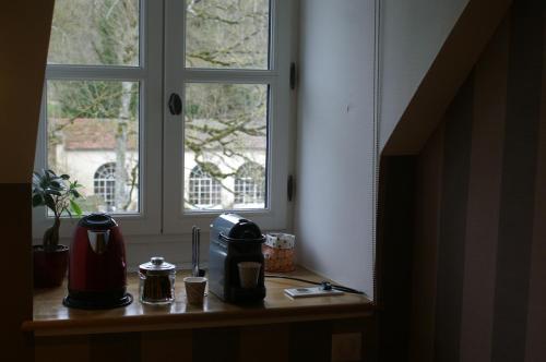 a table with a coffee maker and a window at B&B Vassy Etaule in Avallon