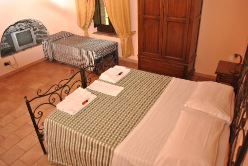 a bedroom with a bed with a table and a tv at Agriturismo Borgo San Nicolao in Randazzo