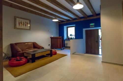 a lobby with a chair and a table and a door at Albergue Orion in Castrojeriz