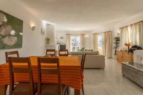 a dining room and living room with a table and chairs at Casa Tulipa in Luz