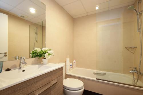 a bathroom with a sink and a tub and a toilet at Atico Be suite Granada in Granada