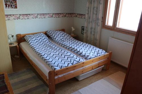 a bed with a wooden frame in a bedroom at Simon tupa Kauhajoki in Kauhajoki