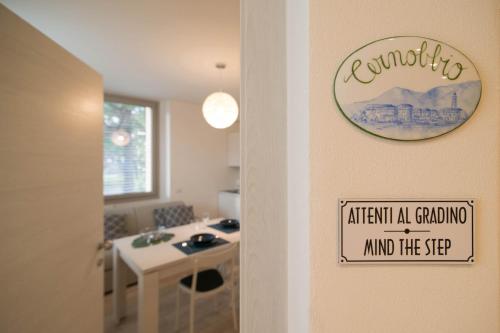 a room with a sign on a wall with a table at Comonfive Apartments in Como