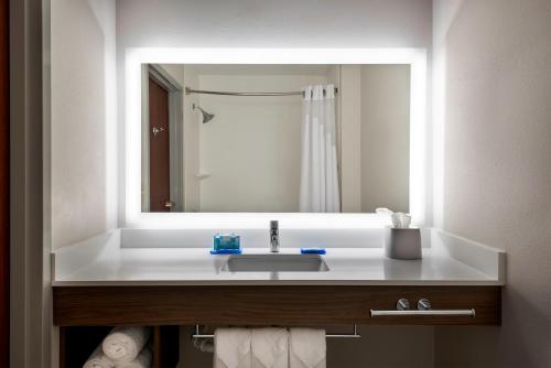 łazienka z umywalką i dużym lustrem w obiekcie Holiday Inn Express Hotel & Suites Charlotte Airport-Belmont, an IHG Hotel w mieście Belmont