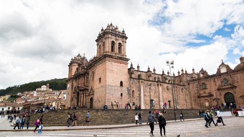 a group of people walking around a large building at Amaru Inca in Cusco