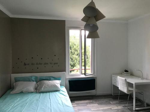 Un dormitorio con una cama azul y una ventana en Appartement 2p Le Havre en Le Havre