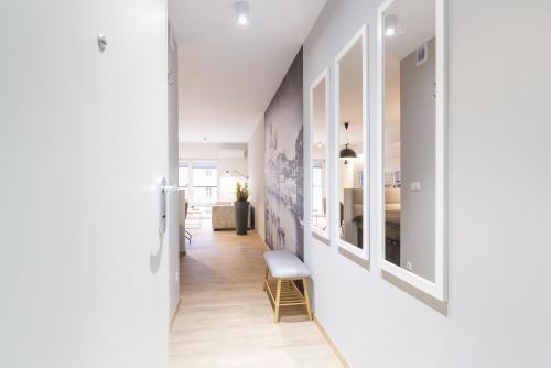 a hallway with white walls and a room with a bed at Venezia Apartment in Poznań