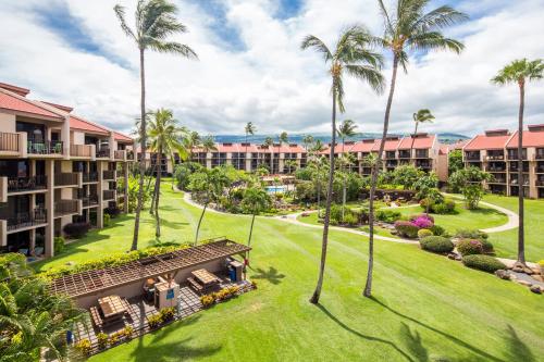 a lush green park with palm trees and palm trees at Castle Kamaole Sands in Wailea