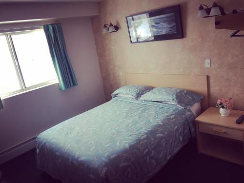 a small bedroom with a bed and a window at Windbreak Cafe in Wasilla