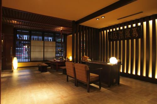 a restaurant with chairs and a table and windows at Onyado Tsutaya in Kiso
