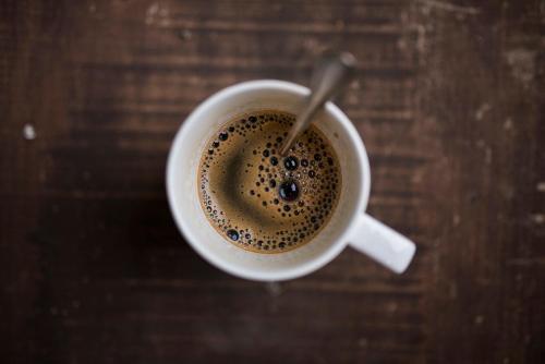 a cup of coffee with a spoon in it at Cabaña en la Calera Cerezos in La Calera