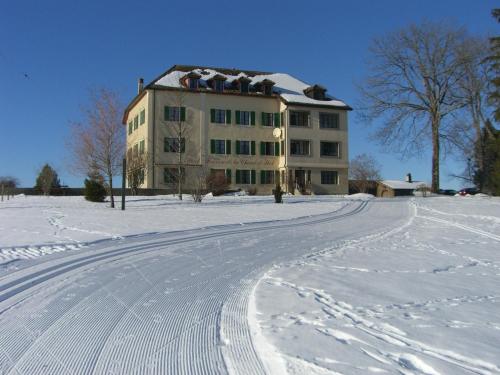 a building in the snow with tracks in the snow at Hôtel de la Chaux-d'Abel in La Ferrière