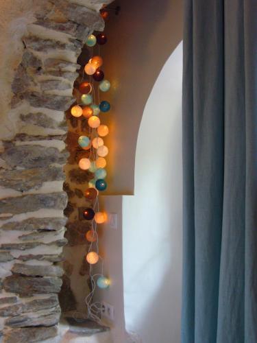 a row of lights hanging from a stone wall at Chambre d'hôtes La Font in Eygliers