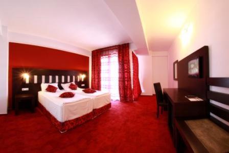 a bedroom with a bed and a desk in a room at Hotel Sydney in Craiova
