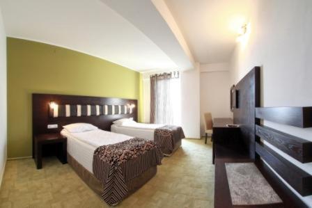 a hotel room with two beds and a television at Hotel Sydney in Craiova