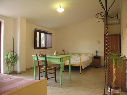 a living room with a green table and a bed at Masseria dei Monelli in Conversano
