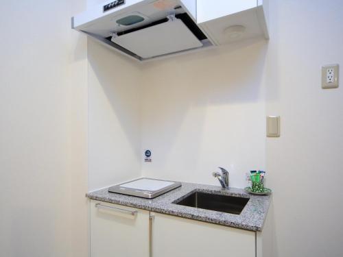 a kitchen with a sink and a counter top at Kamon Inn Hieijocho in Kyoto