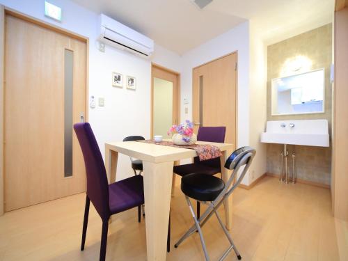 a room with a table and chairs and a sink at Kamon Inn Hieijocho in Kyoto
