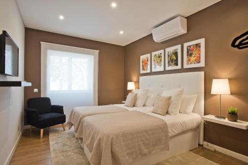 カスカイスにあるCentral Apartment 127 by Saboia Collectionのベッドルーム(大型ベッド1台、椅子付)