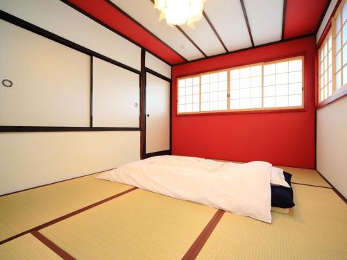 a bedroom with red and white walls and a bed at カモンイン 稲荷 in Kyoto