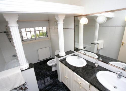 a bathroom with two sinks and a mirror and a toilet at The White House in Larnaka