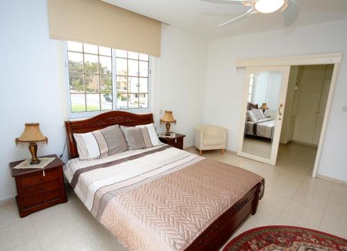ein Schlafzimmer mit einem großen Bett und einem Fenster in der Unterkunft The White House in Larnaka