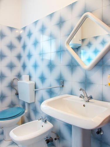 a blue tiled bathroom with a sink and a toilet at Apartment Stana in Novi Vinodolski