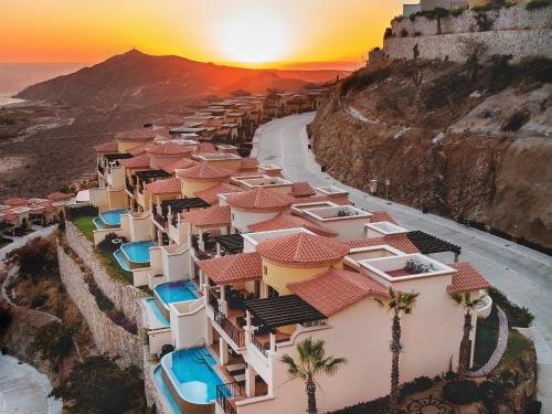 arial view of a resort on the cliff with the sunset at Montecristo Villas at Quivira Los Cabos -Vacation Rentals in Cabo San Lucas