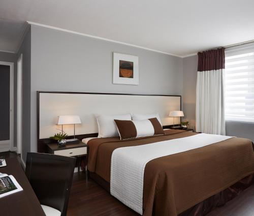 馬尼拉的住宿－Astoria Plaza，酒店客房设有一张大床和一张书桌。