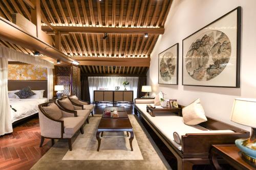 a living room with a couch and a bed at Water Hotel, Pingyao in Pingyao