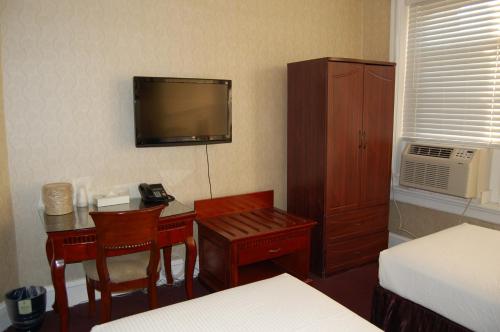 a hotel room with a desk and a tv on the wall at The Baron Hotel in Washington, D.C.