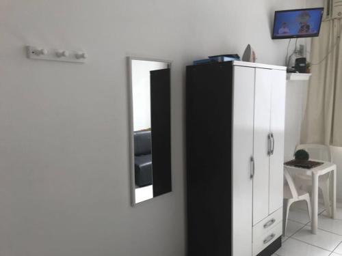 a room with a black and white cabinet and a mirror at Studio Copacabana in Rio de Janeiro