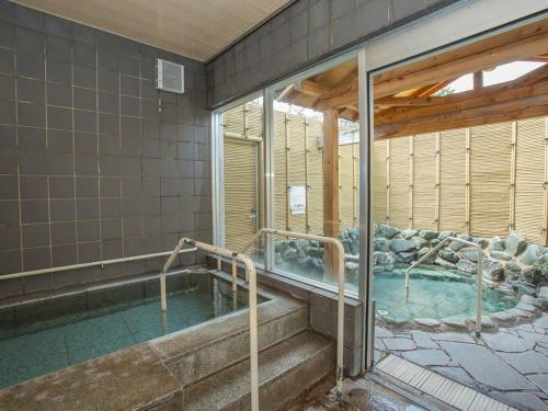 a large swimming pool in a building with at Itoen Hotel Kusatsu in Kusatsu