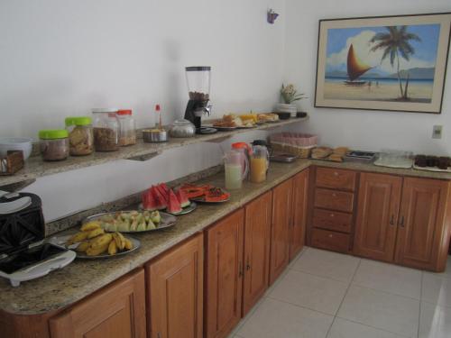 una cocina con encimera con platos de comida. en Pousada Malu, en Fortaleza