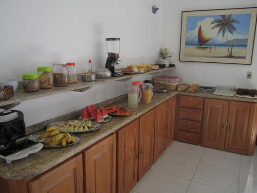 a kitchen with a counter with plates of food on it at Pousada Malu in Fortaleza