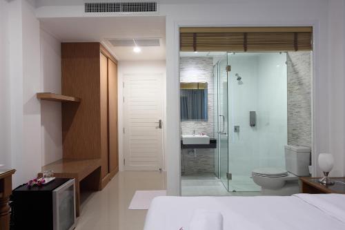 ein Bad mit einem WC und einer Glasdusche in der Unterkunft Clear House Resort - SHA Extra Plus in Kamala Beach