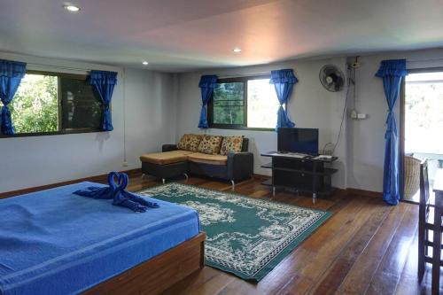 a bedroom with a blue bed and a couch at Gila's Garden in Lamai