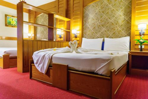 a bedroom with a bed with two swans on it at โรงแรมศิริโฮเต็ล Sirihotel Korat in Nakhon Ratchasima