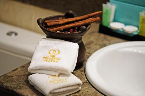 uma casa de banho com um lavatório, toalhas e um WC. em The Bellezza Hotel Suites em Jakarta
