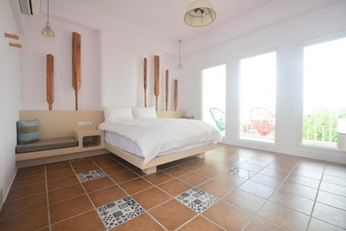 a bedroom with a bed and a tiled floor at Mare Cielo in Xiaoliuqiu