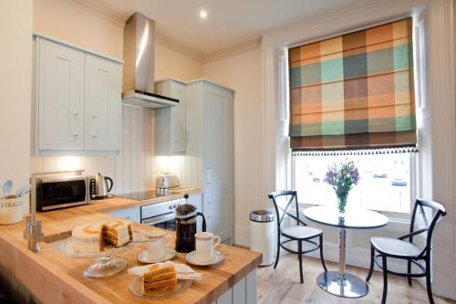 a kitchen with a counter with a table and chairs at Portland Apartments in Cheltenham
