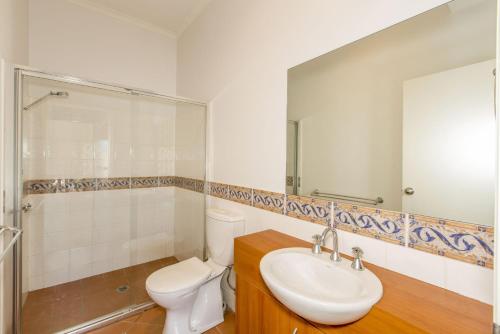 a bathroom with a toilet and a sink and a mirror at STYLISH, SUN-DRENCHED AND SOPHISTICATED in Inverloch
