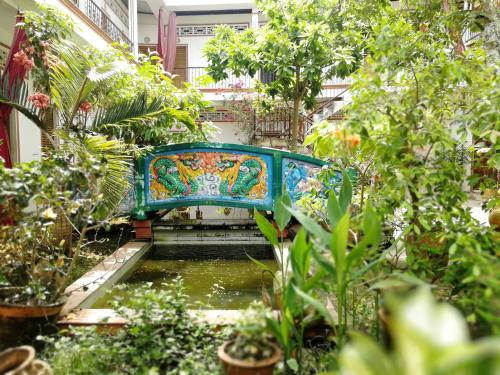 a colorful bench over a pond in a garden at Happy Family Guesthouse in Vĩnh Long